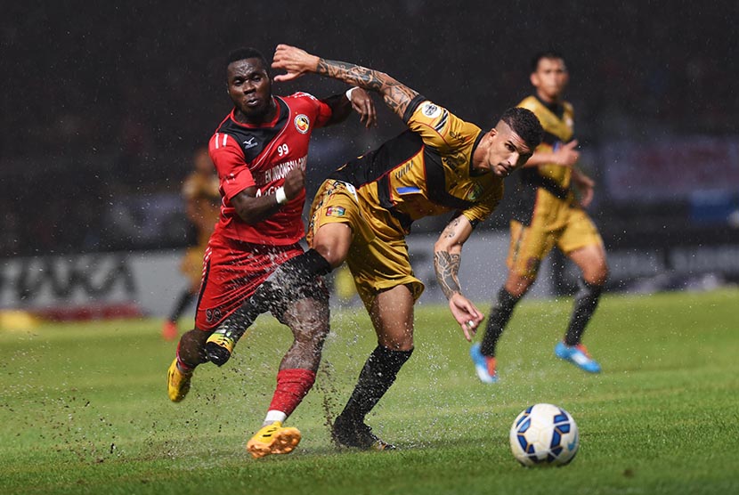 Pesepakbola Semen Padang James Koko Lomel (kiri) berebut bola dengan pesepakbola Mitra Kukar Arthur CH saat laga Final Piala Jenderal Sudirman di Stadion Utama Gelora Bung Karno, Jakarta, Ahad (24/1). 