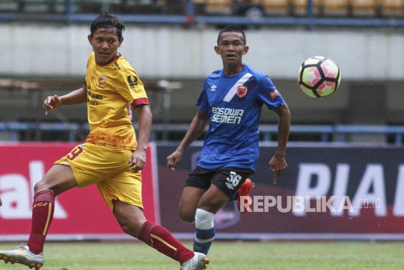 Pesepakbola Sriwijaya FC Adam Salis (kiri) berebut bola dengan pesepakbola PSM Makassar Ahmad Hari (kanan) pada laga lanjutan Grup A Piala Presiden 2018 di Stadion Gelora Bandung Lautan Api, Bandung, Jawa Barat, Ahad (21/1). 
