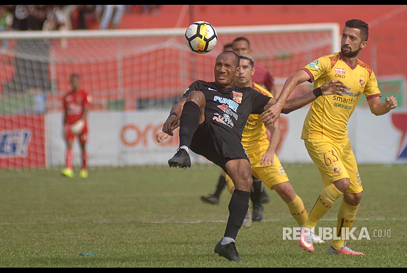 Pesepakbola Sriwijaya FC, Manuchehr Jalilov (kanan) berebut bola dengan pemain Borneo FC, Leonard Tupamahu (kiri), pada pertandingan lanjutan Gojek Liga 1, di Stadion GOR H Agus Salim, Padang.