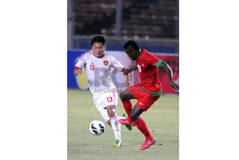   Pesepakbola timnas Indonesia, Greg Nwokolo (kanan) berebut bola dengan pemain Cina saat laga kualifikasi Piala Asia 2015 di Stadion Utama Gelora Bung Karno, Jakarta, Selasa (15/10).  (Republika/ Wihdan)