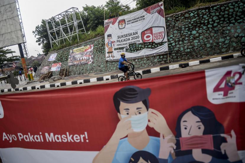 [Foto ilustrasi] Pesepeda melintas di dekat spanduk sosialisasi Pemilihan Kepala Daerah (Pilkada) yang terpasang di Serpong, Tangerang Selatan.