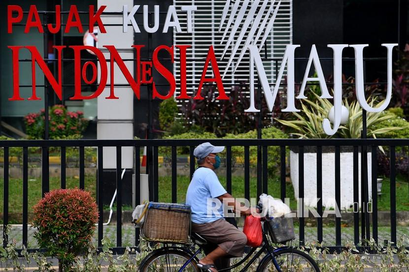 Pesepeda melintas di depan tulisan Pajak Kuat Indonesia Maju di Jakarta Pusat, Sabtu (19/12/2020). OECD menilai kepatuhan pajak di Indonesia buruk. (ilustrasi)