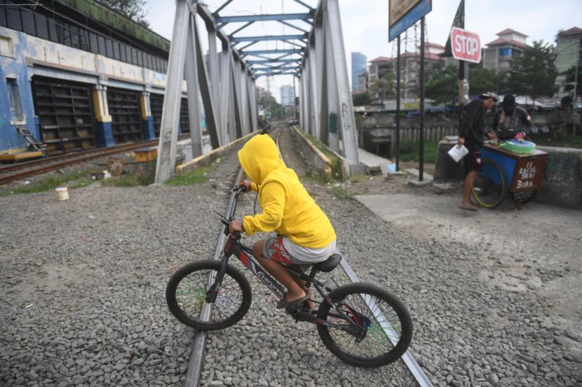 Pesepeda melintasi perlintasan KM 8+2/3 petak jalan Tanahabang - Palmerah yang kembali dapat dilewati meskipun sebelumnya telah ditutup oleh PT KAI Daop 1 di Jakarta, Jumat (24/6/2022). PT KAI Daop 1 Jakarta menutup 6 perlintasan liar yang rawan terjadi kecelakaan di kawasan Jabodetabek, namun perlintasan Tanahabang - Palmerah yang baru ditutup pada Selasa (21/6/2022) tersebut kembali dibuka untuk pesepeda motor oleh warga dan pengguna jalan untuk mempersingkat waktu tempuh. 