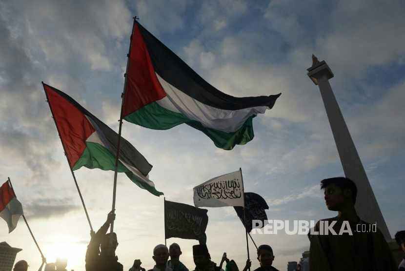 Peserta aksi bela Palestina memadati kawasan Lapangan Monas, Jakarta, Ahad (17/12).