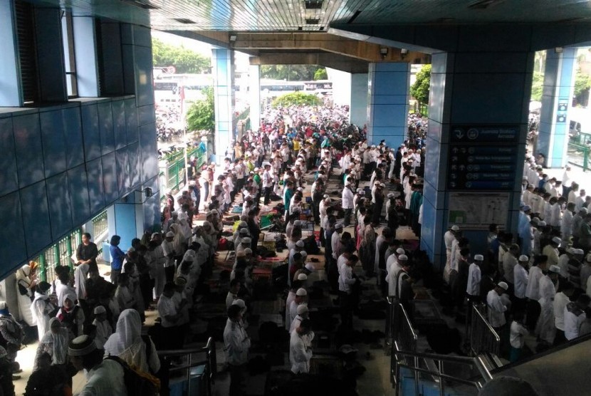 Peserta aksi damai 2 Desember Shalat Jumat di Stasiun Juanda, Jakarta, Jumat (2/12), dikarenakan lapangan Monas sudah dipenuhi massa.