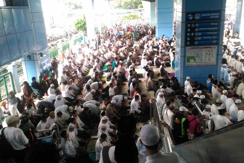 Peserta Aksi Damai 2 Desember Shalat Jumat di Stasiun Juanda, Jakarta, Jumat (2/12).