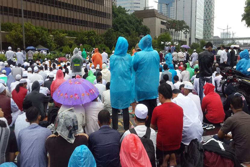 Peserta aksi damai basah kuyup saat mendengarkan ceramah Shalat Jumat.