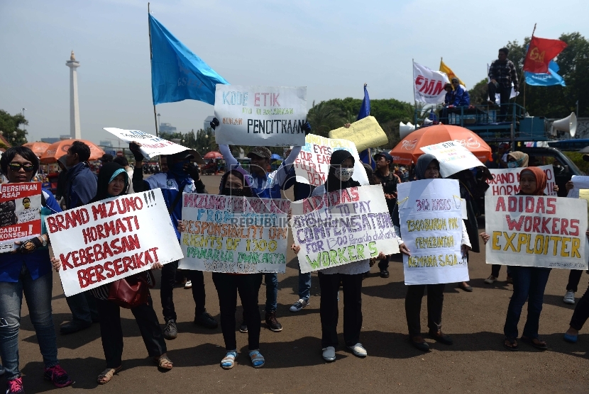 Peserta aksi dari Gabungan Serikat Buruh Indonesia (GSBI) menggelar aksi unjuk rasa dalam rangka setahun pemerintahan Jokowi-JK di depan Istana Merdeka, Jakarta, Selasa (20/10).  (Republika/Wihdan)