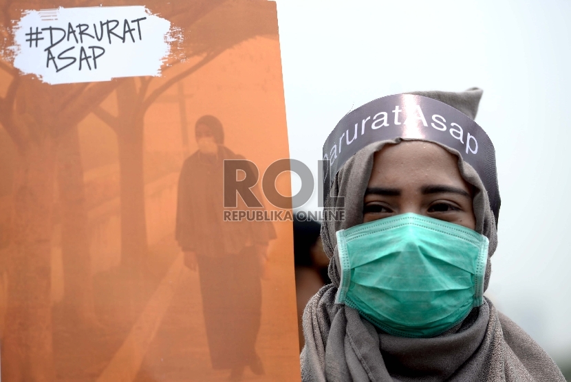 Peserta aksi dari Masyarakat Relawan Indonesia (MRI) menggelar aksi simpatik darurat asap di Silang Monas, Jakarta, Senin (26/10).  (Republika/Wihdan)