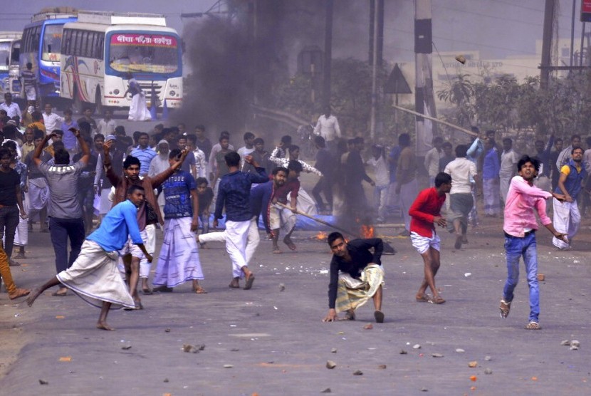 Peserta aksi melempari polisi dengan batu, Sabtu (14/12). Aksi protes ini berawal dari pengesahan UU Kewarganegaraan yang berisi pemberian kewarganegaraan India berdasarkan agama, kecuali Islam.