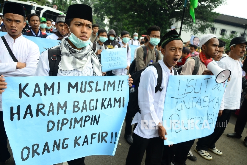  Peserta aksi membentangkan poster di depan Gedung Sate, Kota Bandung, pada Aksi demonstrasi umat Islam terkait pernyataan kontoversi Gubernur DKI Jakarta, Basuki Tjahaja Purnama atau Ahok yang mengutip salah satu ayat Alquran, Jumat (21/10). 