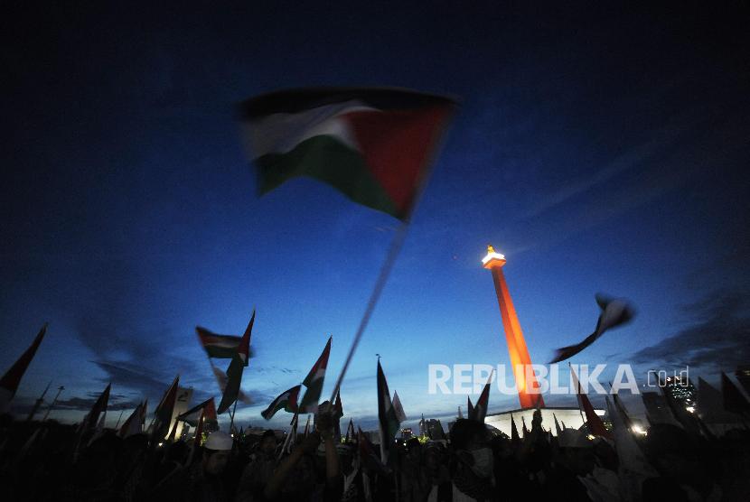 Indonesian people raise the Palestinian flag during the Palestinian solidarity rally at the National Monument, Jakarta, Sunday (Dec 17, 2017).