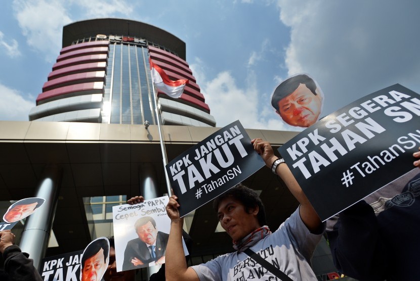 Peserta aksi yang tergabung dalam Koalisi Masyarakat Sipil Antikorupsi membawa poster bergambar Ketua DPR Setya Novanto ketika melakukan aksi di depan Gedung KPK, Jakarta, Kamis (14/9). 