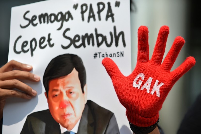Peserta aksi yang tergabung dalam Koalisi Masyarakat Sipil Antikorupsi membawa poster bergambar Ketua DPR Setya Novanto ketika melakukan aksi di depan Gedung KPK, Jakarta, Kamis (14/9). 