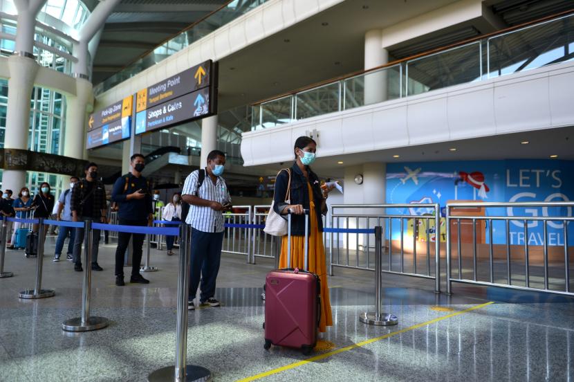 Peserta antre meninggalkan area bandara untuk menuju ke hotel karantina saat kegiatan simulasi penerbangan internasional di Bandara Internasional I Gusti Ngurah Rai, Badung, Bali, Sabtu (9/10/2021). 