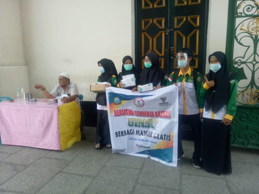 Peserta Beasiswa Cendekia Baznas  (BCB)  UIN Sumatera Utara membagikan masker kepada masyarakat di sekitar Masjid Raya dan Istana Maimun Medan.