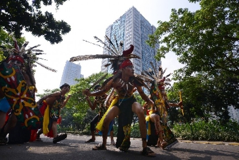 Peserta beraksi dalam Karnaval Budaya Dayak di Jalan Jenderal Sudirman, Jakarta
