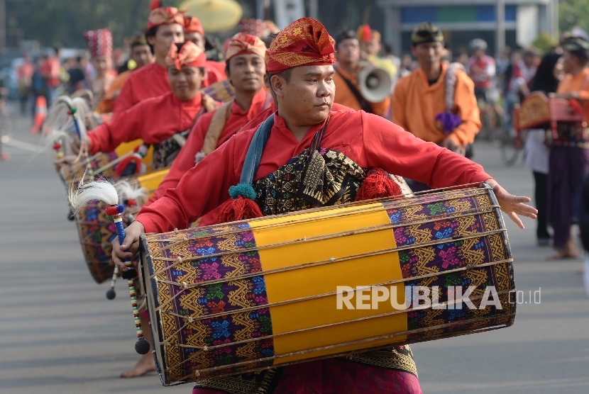  Peserta karnaval budaya Nusa Tenggara Barat (NTB) memainkan gendang Belek saat promosi budaya dan pariwisata Lombok Sumbawa di car free day Jalan Thamrin, Jakarta, Ahad (17/7).  (Republika/Yasin Habibi) 