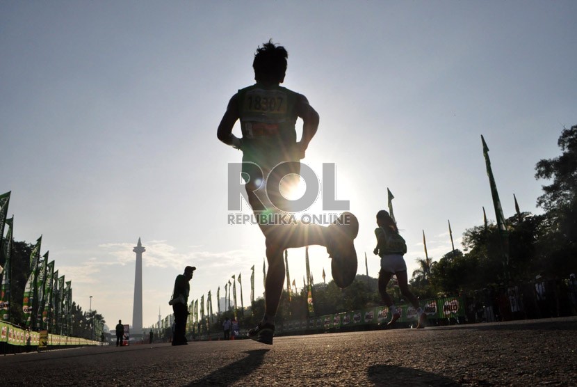  Peserta lomba lari Jakarta International 10K saat menuju garis finish di kawasan silang Monas, Jakarta Pusat, Ahad (23/6).  (Republika/Rakhmawaty La'lang)