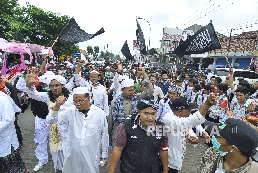 Peserta long march berjalan kaki dalam aksi Bela Islam 212 Jilid III dari Ciamis ke Jakarta di Jalan Raya Rancaekek, Kabupaten Bandung, Rabu (30/11). 