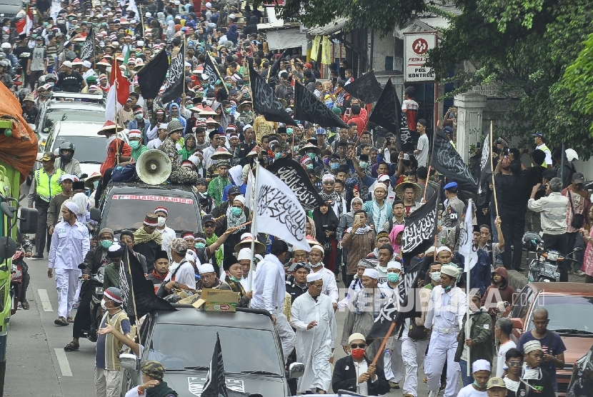 Peserta long march berjalan kaki dalam aksi Bela Islam 212 Jilid III dari Ciamis ke Jakarta di Jalan Raya Rancaekek, Kabupaten Bandung, Rabu (30/11). 