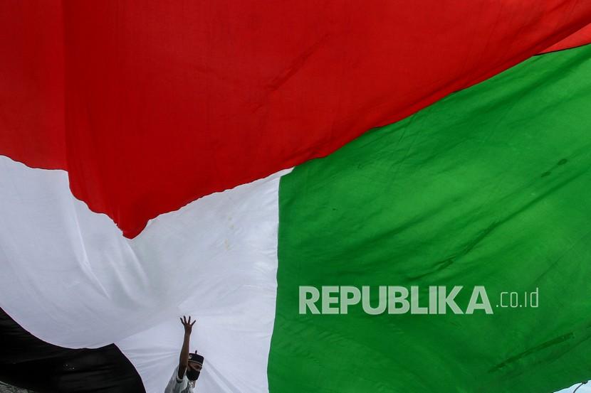 Peserta membawa bendera Palestina saat menggelar aksi solidaritas (ilustrasi)