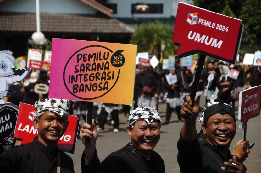 Peserta membawa poster bertuliskan tentang pemilu 2024 saat serah terima kirab Pemilu 2024 di Slawi, Kabupaten Tegal, Jawa Tengah.