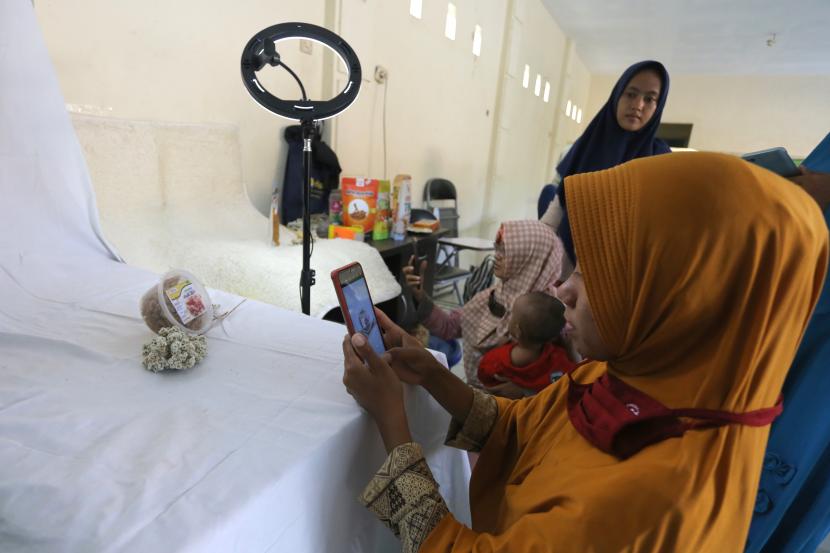 Peserta mempraktikkan cara memotret produk saat pelatihan fotografi produk UMKM di desa Kenanga, Indramayu, Jawa Barat, Minggu (17/10/2021). Selama pandemi, UMKM yang mampu bertahan adalah yang beroperasi secara hybrid.