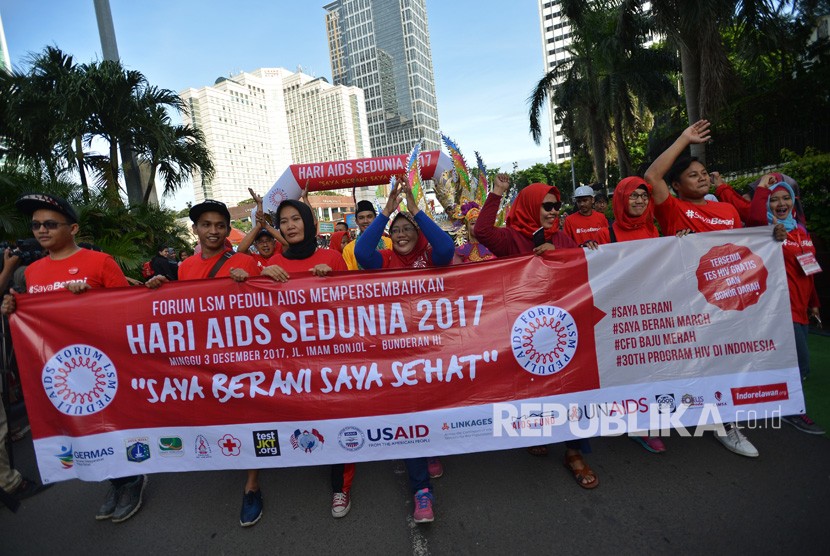 Peserta mengikuti jalan santai dalam rangka peringatan Hari Aids Sedunia yang diselenggarakan oleh Forum LSM Peduli AIDS di Kawasan Bundaran HI Jakarta, Ahad (3/12).