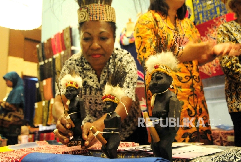 Peserta pameran asal Papua memamerkan miniatur patung dalam pameran ekonomi kreatis Usaha Mikro Kecil Menengah (UMKM) binaan BI di Balai Kartini, Jakarta, Jumat (26/8). 