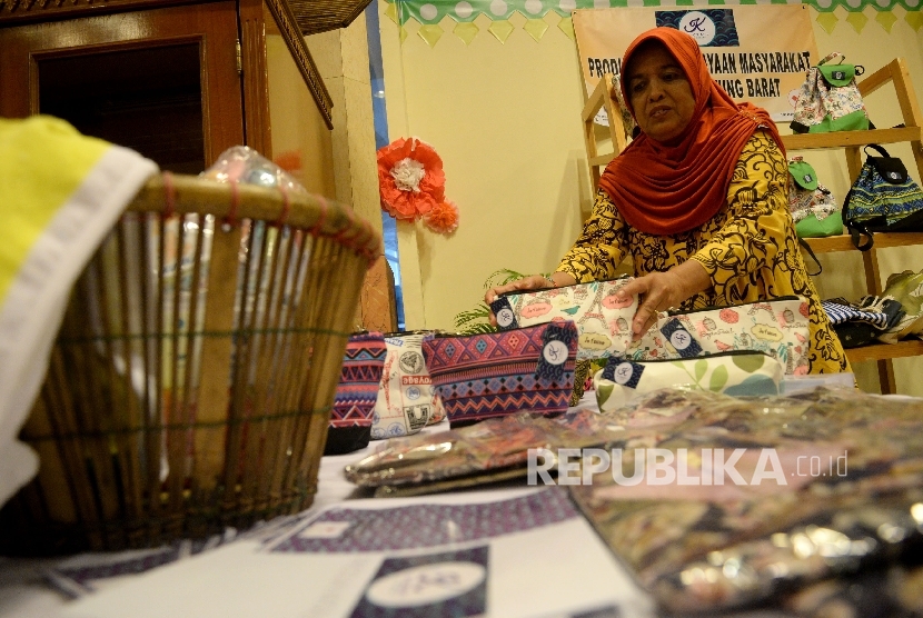 Peserta pameran Ekonomi Kreatif Rusunawa Jakarta (E-Kerja) menata hasil kerajinan ketika mengikuti pameran di Gedung Blok G, Balaikota Jakarta, Rabu (26/4).