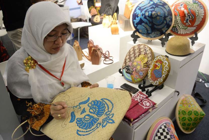 Peserta pameran melukis kerajinan tas pada Pameran Kriyanusa 2018 di Jakarta, Rabu (26/9). Pameran Kriyanusa yang menampilkan karya kreatif kerajinan nusantara tersebut berlangsung hingga 30 September 2018.