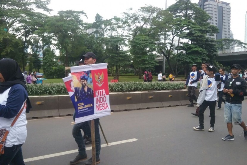 Peserta Parade Kebudayaan mengenakan kaos beratribut partai di Jakarta pada Ahad (4/12).