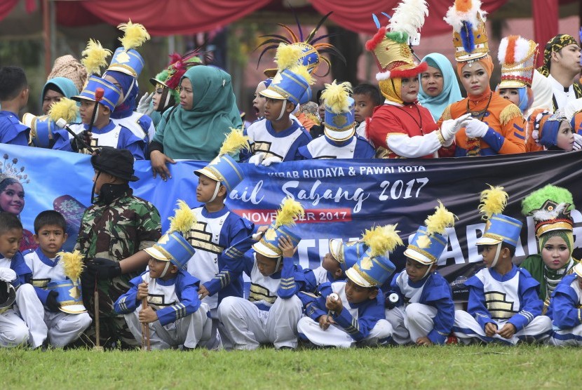 Peserta pawai menyaksikan Genderang Suling Gita Jala Taruna bermain musik saat Kirab Kota dan Pawai Budaya Sail Sabang di Sabang, Aceh, Rabu (29/11).