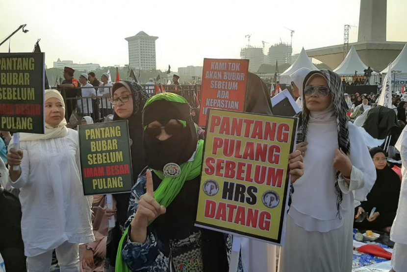 Peserta Reuni 212 membawa poster yang menginginkan Habib Rizieq Shihab segera dikembalikan ke Indonesia.