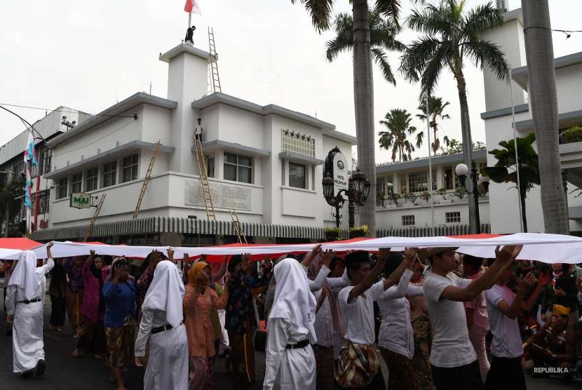 Peserta teatrikal membentangkan bendera Merah Putih saat memperingati peristiwa perobekan bendera di Hotel Yamato sekarang Hotel Majapahit di Jalan Tunjungan, Surabaya, Jawa Timur, Rabu (19/9). 