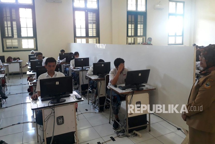 Peserta UNBK SMA 5, mengikuti ujian secara bergantian karena keterbatasan komputer, Senin (9/4).