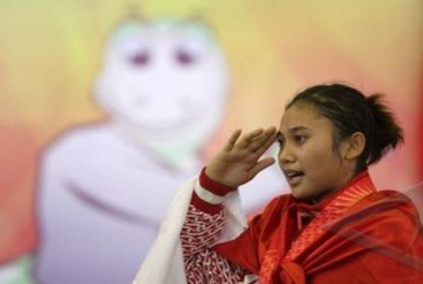 Pesilat Indonesia, Amelia Roring, menyanyikan lagu Indonesia Raya saat menerima medali emas kelas E 65-70 kg SEA Games XXVI di Padepokan Pencak Silat, Taman Mini Indonesia Indah (TMII), Jakarta Timur, Kamis (17/11).