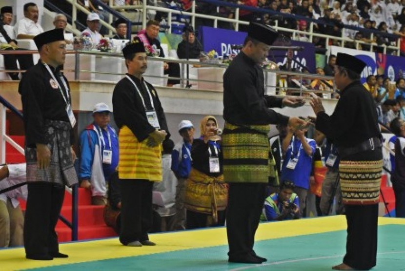 Pesilat Senior Tri Sipit S (kanan) menyerahkan senjata golok kepada Wakil Ketua PB IPSI Edhy Prabowo (kedua kanan) saat seremoni 