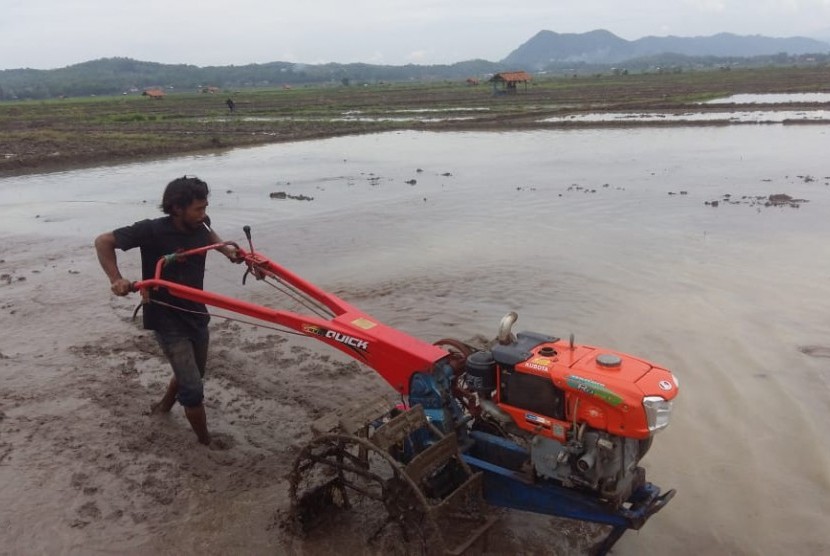 Petani asal Desa Gunungkarung, Kecamatan Maniis, Purwakarta, mulai membajak sawahnya dengan menggunakan traktor saat musim penghujan 2018 ini, Rabu (14/11). 