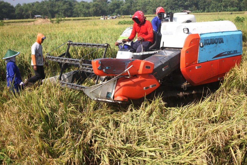 Petani menggunakan mesin pemanen padi untuk mempercepat proses panen di desa Pacing, Ngawi, Jawa Timur, Rabu (24/2)