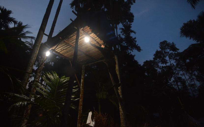 Petani menyalakan lampu di rumah pohon penjaga ladang di Korong Patamuan, Nagari Padang Alai, Kabupaten Padangpariaman, Sumatera Barat, Sabtu (20/2). Pemerintah mencatatkan konsumsi listrik mengalami kenaikan sebesar 3,3 persen per Maret 2021. 