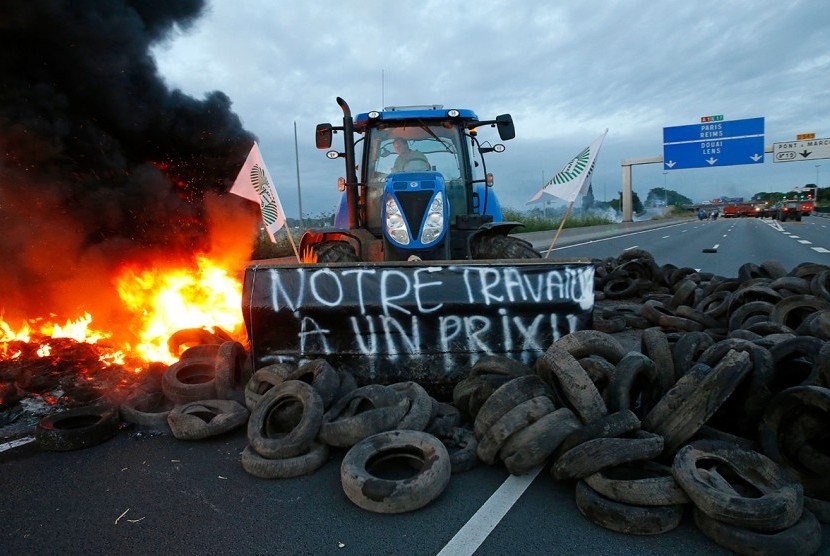 Petani Prancis memblokir truk-truk bermuatan produk pertanian dengan traktor memprotes rendahnya harga produk pertanian dalam negeri, Ahad (26/7).