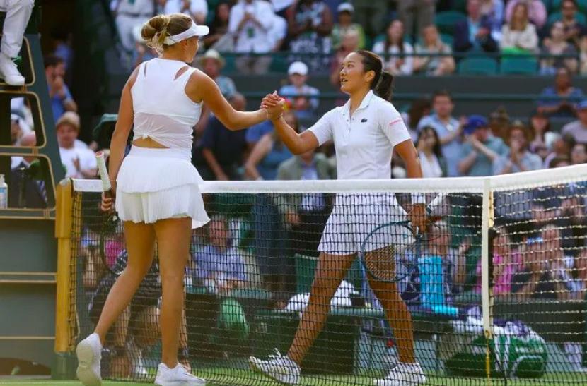 Petenis AS Amanda Anisimova (kiri) dan petenis Prancis Harmony Tan (kanan) berjabat tangan setelah pertandingan babak keempat di All England Lawn Tennis and Croquet Club, London, Inggris, Senin (4/7/2022)