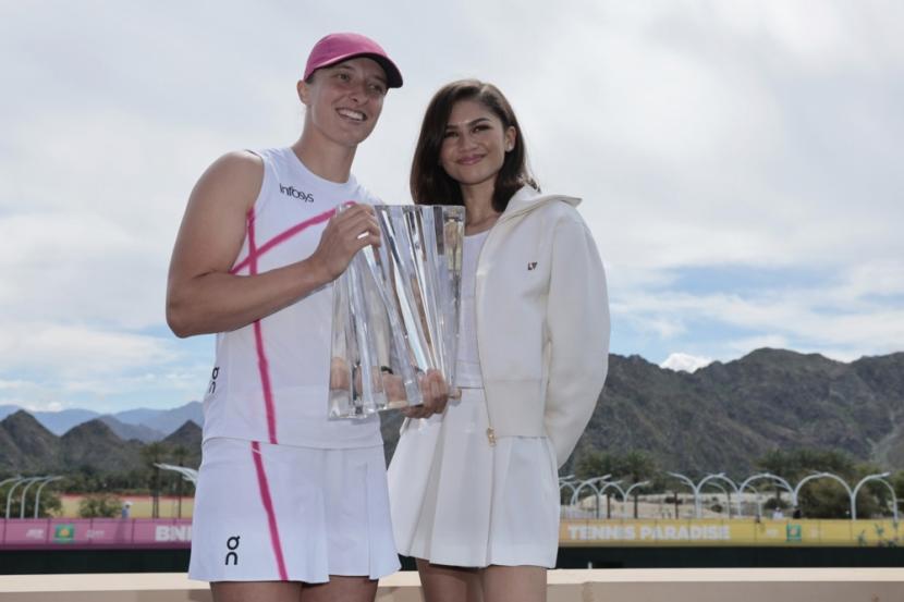 Petenis asal Polandia Iga Swiatek (kiri) berpose bersama aktris Zendaya sambil memegang trofi turnamen tenis BNP Paribas Open di Indian Wells, California, AS, 17 Maret 2024.