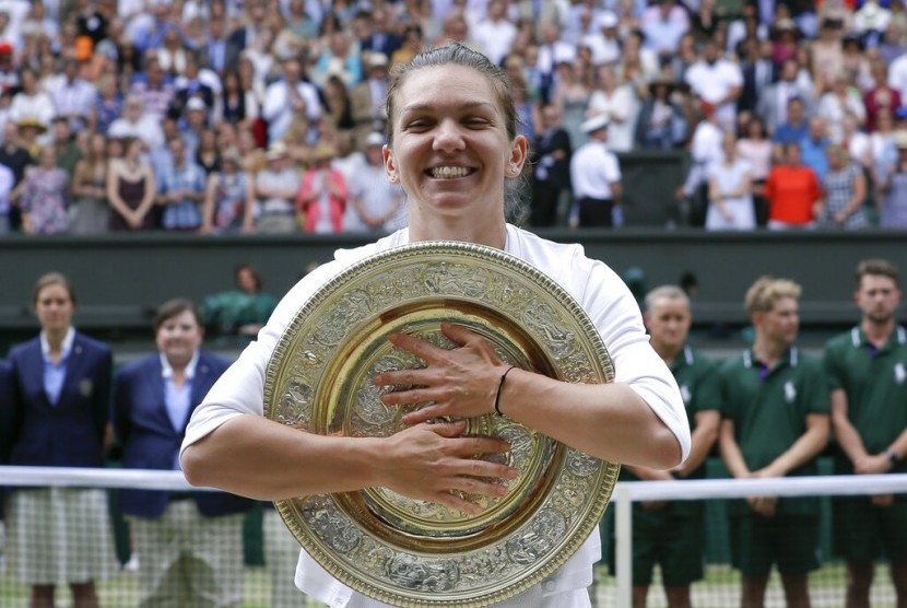 Petenis Rumania, Simona Halep memeluk trofi Wimbledon 2019. Grand slam Wimbledon 2020 kemungkinan ditunda akibat virus corona.