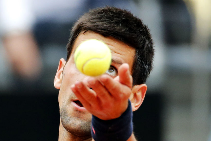 Petenis Serbia, Novak Djokovic, bersiap melakukan servis ketika menghadapi petenis Spanyol, David Ferrer, di perempat final Roma Masters pada Jumat (16/5). 