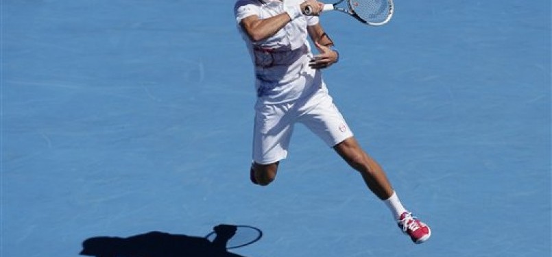 Petenis Serbia, Novak Djokovic, melepaskan pukulan forehand saat menghadapi petenis Kolombia, Santiago Giraldo, di putaran kedua turnamen Australia Terbuka di Melbourne, Australia, Kamis (19/1). 