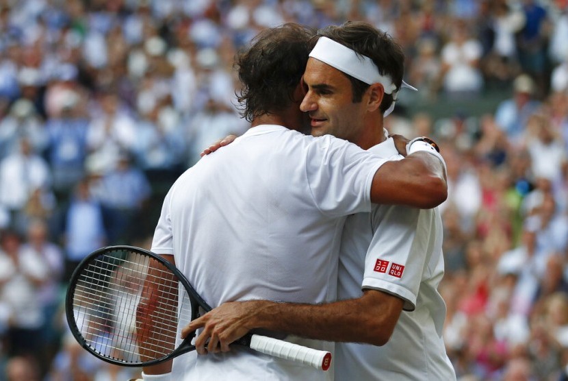 Petenis Swis Roger Federer (kanan) dan Rafael Nadal berpelukan usai pertandingan semifinal Wimbledon di London, Jumat (12/7) waktu setempat. Federer melaju ke final dan bertemu Novak Djokovic.