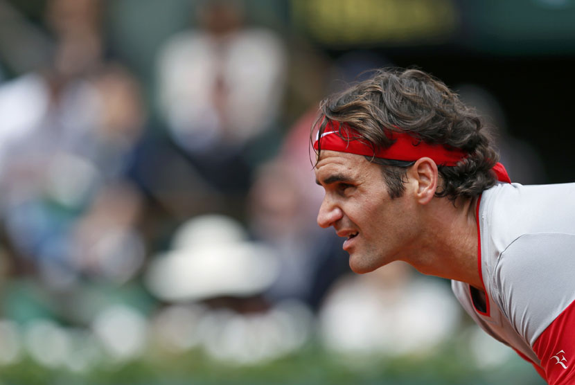 Petenis Swiss, Roger Federer, bersiap menerima servis pemain Slovakia, Lukas Lacko, dalam pertandingan turnamen Prancis Terbuka di Roland Garros, Paris, Sabtu (25/5). 